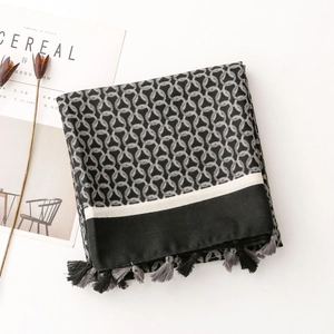 Close-up of geometric ring print scarf with fringe trim and minimalist herringbones