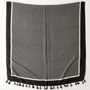 Detail of herringbone weave scarf with geometric chain prints and tassel edge