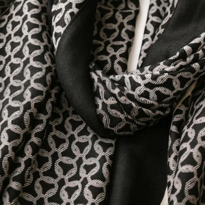 Close-up of interlocking circle pattern on a warm woven scarf with herringbone texture
