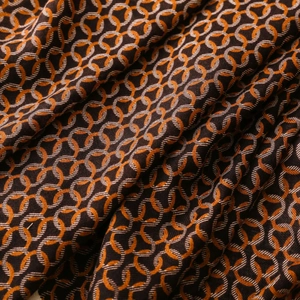 Detailed close-up of herringbone weave scarf with vintage circular ring pattern and tassels