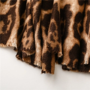 Dettaglio macro del morbido scialle con stampa leopardata e trama in finto cashmere