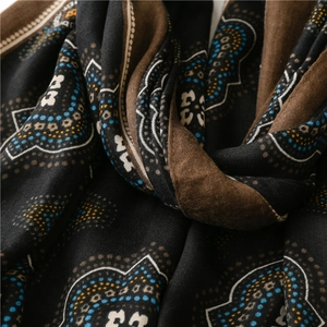Dettaglio di sciarpa boho con stampa floreale, motivi geometrici e consistenza morbida
