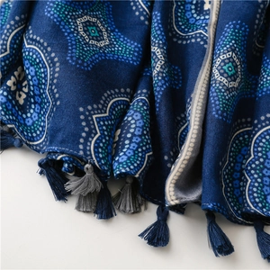 Dettaglio di sciarpa mandala bohémien con bordi a frange e nappe blu e grigio