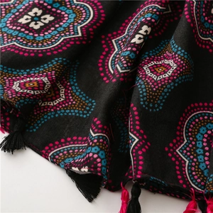 Dettaglio della sciarpa mandala boho con motivi a pois colorati e bordo con nappe