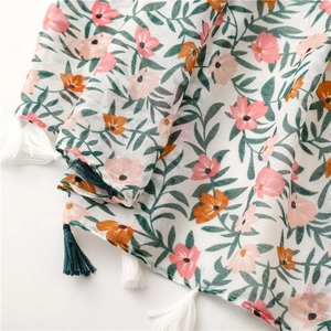 Close-up of floral linen scarf with tropical pink flowers and two-tone fringe tassels
