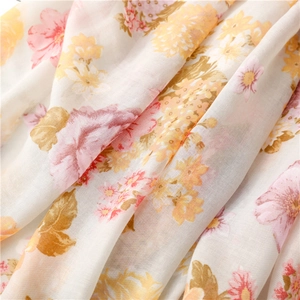 Close-up of vintage floral cotton-linen scarf fabric with soft texture and tassels