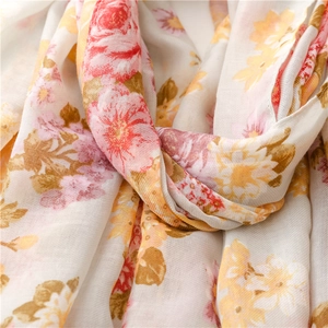 Detailed macro view showing soft fabric texture and colorful floral prints on the scarf