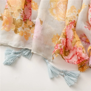 Detail shot of vintage floral pattern scarf with delicate light blue fringe tassels
