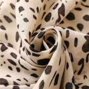 Detail shot of soft cotton-linen fabric with black polka dots and herringbone weave