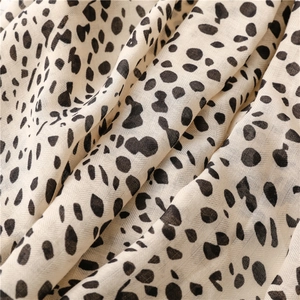 Detailed macro view of cream spotted fabric with fine woven texture and leopard print