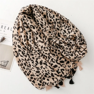 Detail of leopard print scarf with soft fringe tassels and woven blend fabric texture
