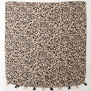 Detailed view of leopard print scarf with dual-tone black and beige fringe tassels
