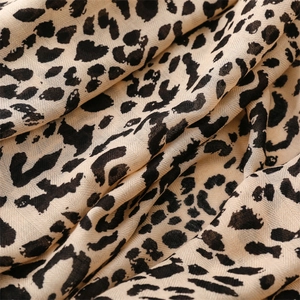 Detailed macro view of soft leopard print fabric with diagonal twill weave texture