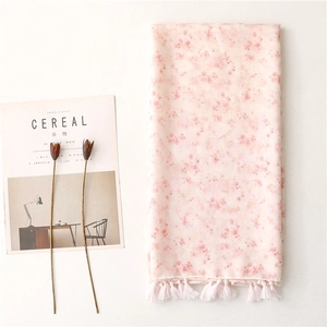 Pink floral cotton linen scarf with tassel fringe edges on minimalist white background