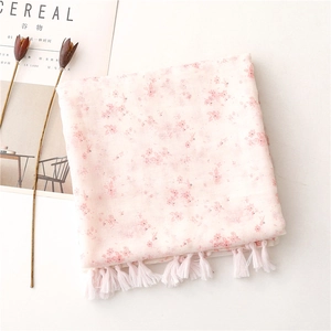 Close-up of pink floral scarf with cotton linen texture and delicate fringe tassels
