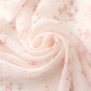 Close-up of pink floral linen scarf fabric showing soft texture and sheer weave
