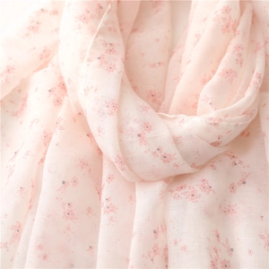Macro detail of breathable pink cotton-linen fabric with delicate floral print and soft texture