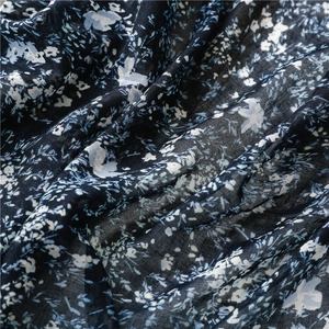 Detail view of navy blue floral fabric texture with white flowers and soft folds