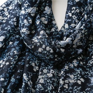 Detailed macro view of the soft navy floral print fabric and fine texture of the scarf