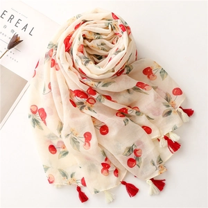 Lightweight cotton linen scarf with red cherry print and tassels on a white background