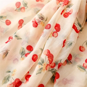 Macro detail of breathable cotton linen fabric with vintage red cherry prints on cream base