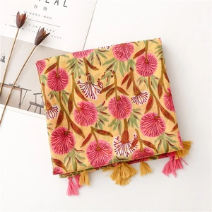 Detail of floral print scarf with pink and yellow tassels on breathable cotton linen