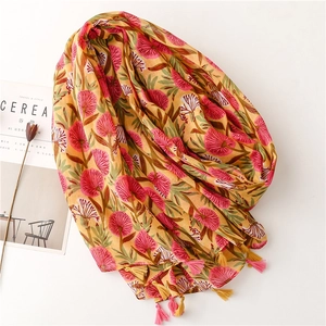 Floral print linen scarf in yellow and pink with elegant tassels on a white background