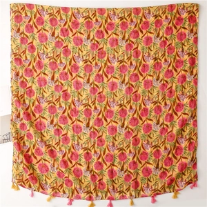 Detail of lightweight yellow floral scarf with pink tassels and hand-painted prints
