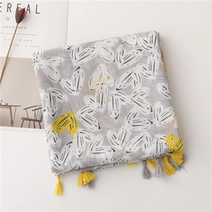 Detailed view of grey and yellow cotton scarf with heart patterns and tassel fringe