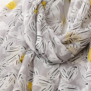 Detailed texture of cotton linen scarf with grey leaf patterns and yellow accents