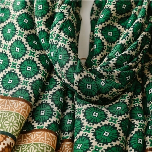 Close-up of vintage floral cotton scarf showing soft texture and detailed fringe hem