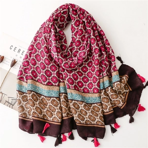 Detail of ethnic geometric patterns and red fringe tassels on a cotton linen scarf