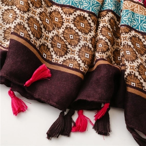 Detail of ethnic geometric floral scarf with thick fringe tassels and textured fabric