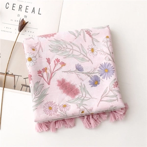 Detail of pink floral cotton scarf with daisy print and elegant tassel fringe edges