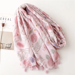 Pink floral cotton scarf with tassels shown with lifestyle magazine and dried flowers