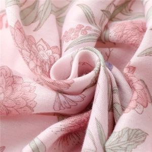 Detail of soft pink floral cotton linen scarf with delicate petal print and woven texture