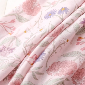 Close-up of lightweight pink floral scarf fabric showing detailed botanical patterns