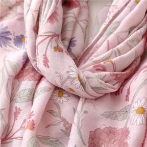 Detail of pink floral cotton scarf with daisy print and soft breathable texture