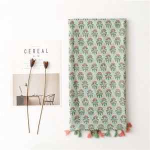 Detail of floral elephant print cotton linen scarf with soft pink and green tassels