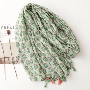 Light green cotton linen scarf with pink floral prints and fringe tassels on white background