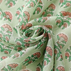 Macro view of light green cotton linen scarf showing soft floral print and texture