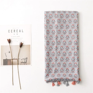 Close-up of floral print cotton scarf with decorative fringe tassels and vintage pattern