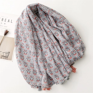 Macro detail of breathable linen-cotton floral scarf featuring delicate fringe tassels