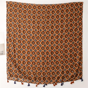 Detail of bohemian orange star flower scarf with tassel trim and geometric patterns