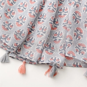 Detail shot of lightweight floral cotton linen scarf featuring pink tassels and patterns