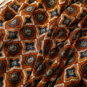 Detail of floral star pattern on lightweight cotton linen scarf with soft fabric texture