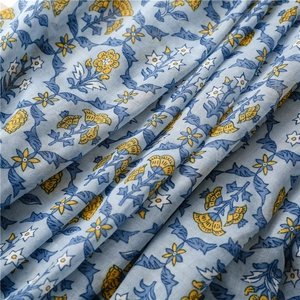 Close-up of light blue cotton linen fabric featuring yellow evening primrose floral patterns