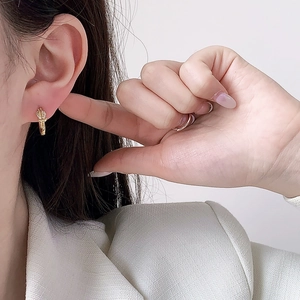 Sparkling pavé zircon cross hoop earrings in 18K gold finish shown on model ear