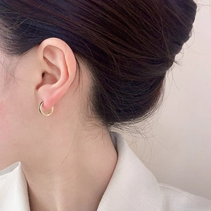 Minimalist gold huggie hoop earrings featuring a polished finish and sleek circular design