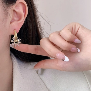 Boucles d'oreilles fleurs dorées avec cristaux de zircone radiants sur modèle